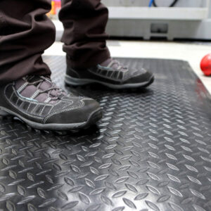 Man standing on a black and yellow deluxe workplace mat