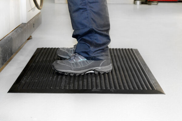 Woman standing on a black Electrostatic Discharge Mat