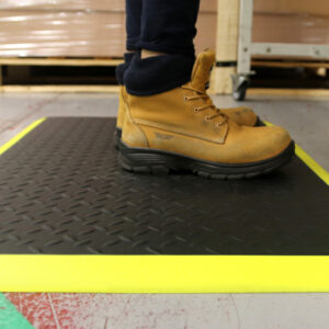Woman standing on a black and yellow Electrostatic Discharge Mat with Diamond detailing