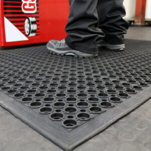 Man standing on a black Honeycombed Detailing mat