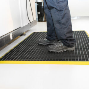 Man standing on black and yellow Workstation mat